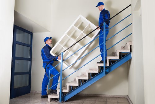 Furniture being carried through a London townhouse interior